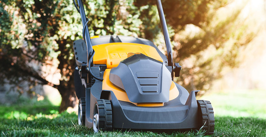 Man mows the lawn with a lawn mower. copy space